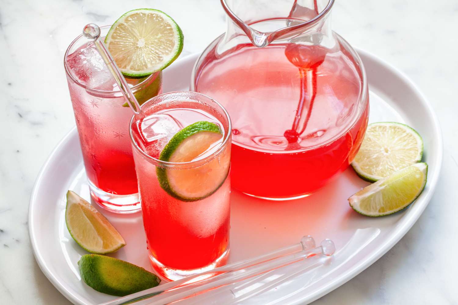 Meilleur raspberry lime rickey jamais réalisé dans deux verres avec un pichet à côté.