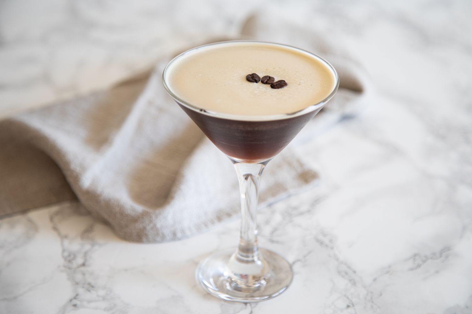 Vue latérale d'un Espresso Martini sur un fond en marbre.