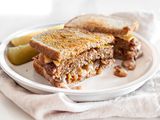 Halved Vegan Patty Melt with Pickles on a Plate over a Table Napkin