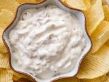 French Onion Dip in a scalloped bowl surrounded by potato chips