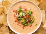 Get ready for game day with a bowl of ceamy queso dip topped with pico de gallo and surrounded by tortilla chips