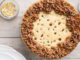 Chocolate Chip Cookie Cake Surrounded by Plates and Small Bowls with Sprinkles and Chocolate Chips