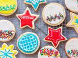 Royal icing for sugar cookies piped into a variety of patterns and sent on a cooling rack.