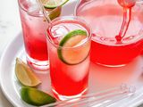 Best ever raspberry lime rickey in two glasses with a pitcher behind it.