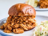 Pulled pork sandwich on a plate with coleslaw.