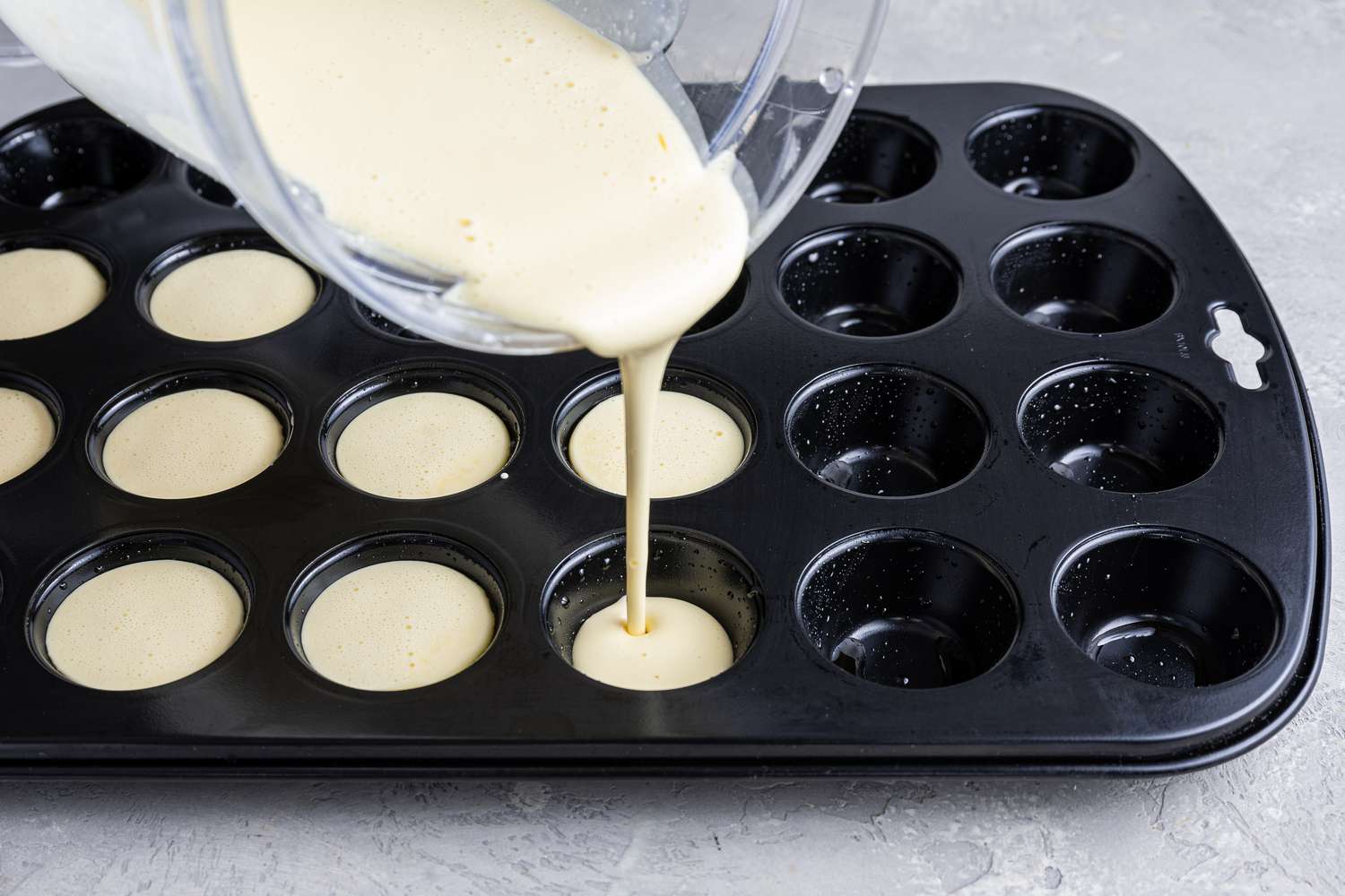 Pâte de pain au fromage brésilien versée dans un moule à muffins