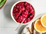 Instant Pot Cranberry Sauce Next to a Bowl of Green Beans and Table Napkin with Orange Slices and Cinnamon Sticks