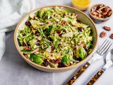 Brussel Sprout Cole Slaw in a Bowl Next to a Bowl of Dressing and Bowl of Pecans