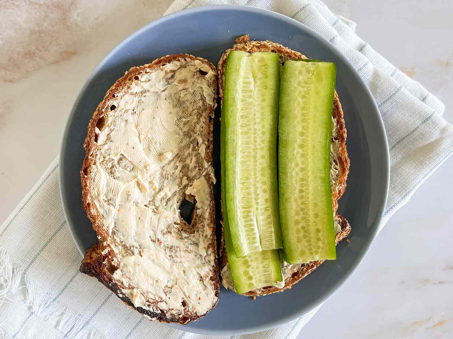 Concombre tranché ajouté aux tranches de pain avec du fromage à la crème