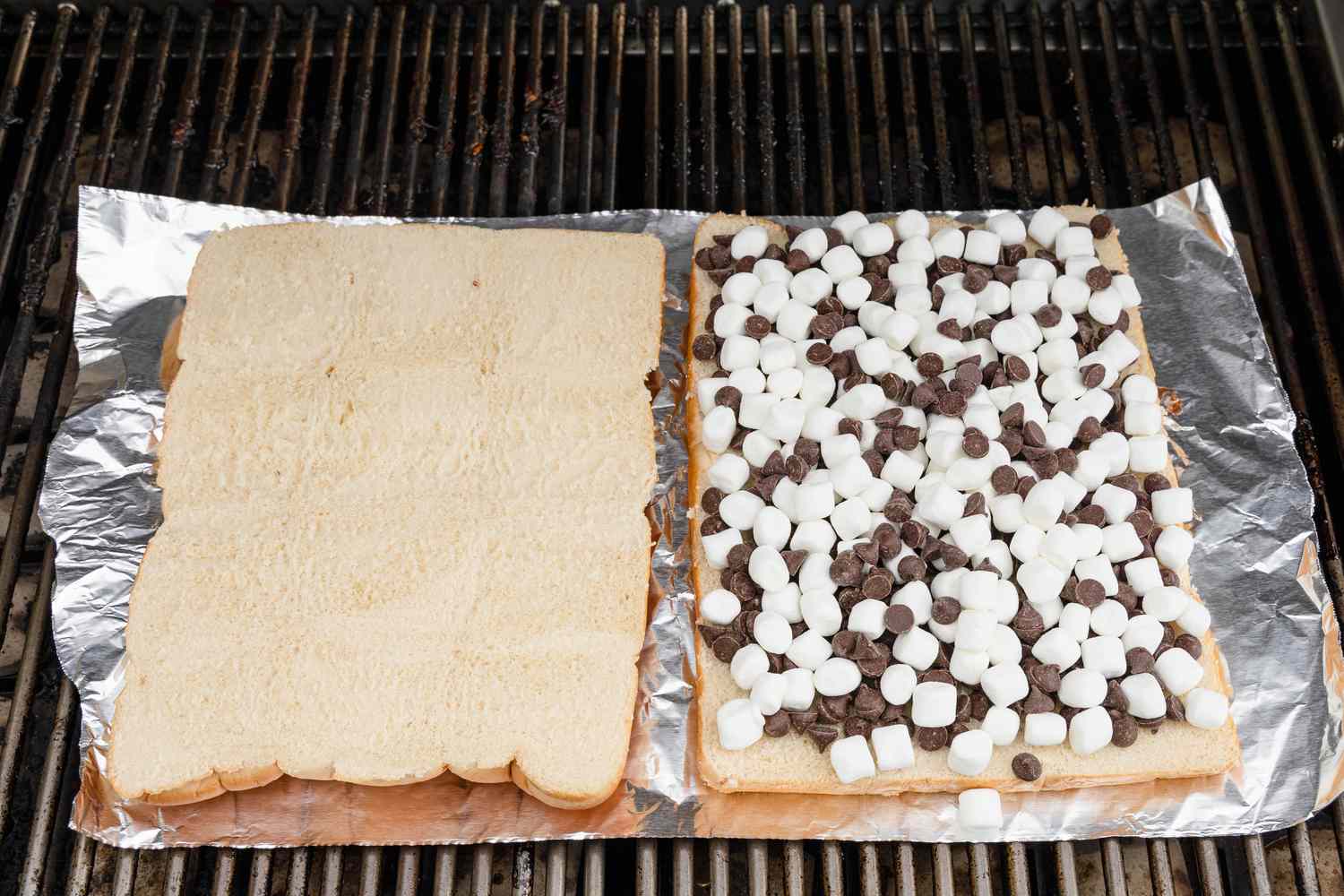 Feuille d'aluminium avec les deux moitiés du pain à slider (une moitié est vide et l'autre a la garniture) sur le grill