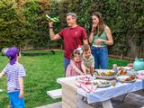 Les parents Pfeffer et leurs trois enfants jouent à l'extérieur à côté d'une table de nourriture