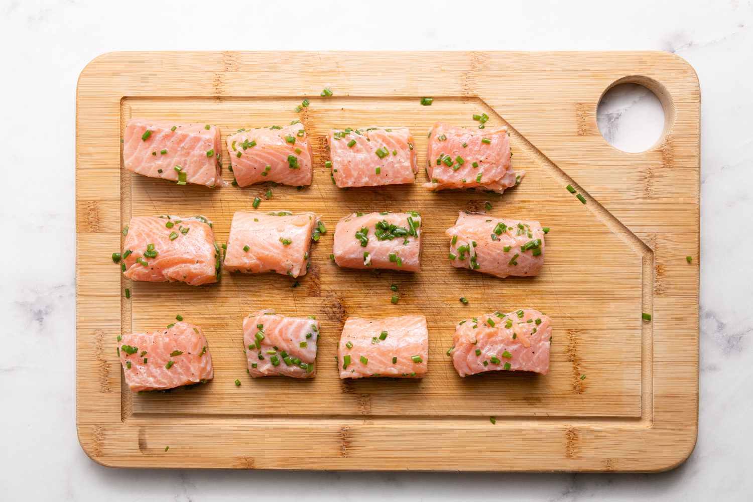 Salmon Seasoned on Cutting Board for Grilled Bacon-Wrapped Salmon Bites with Lemon Garlic Mayo