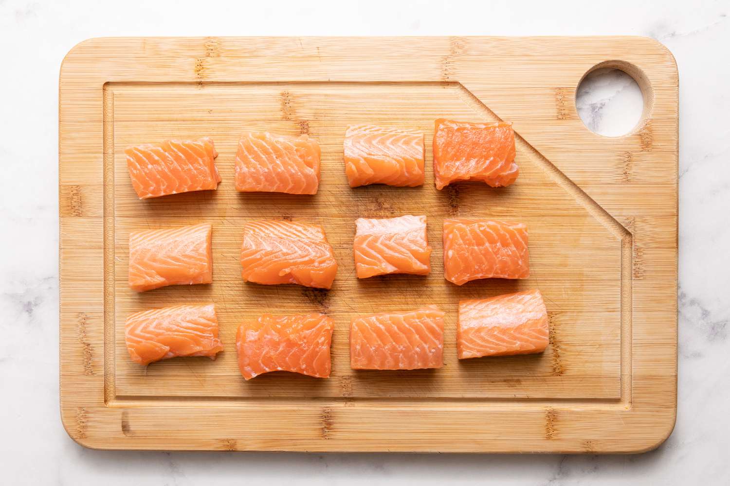 Salmon on Cutting Board for Grilled Bacon-Wrapped Salmon Bites with Lemon Garlic Mayo