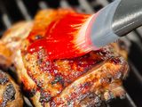 Grilled chicken with paste being brushed on