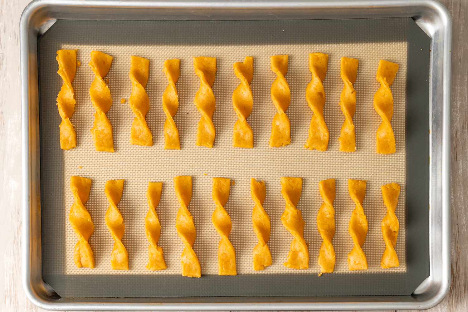 Lined Baking Tray with Uncooked Twisted Cheese Straws