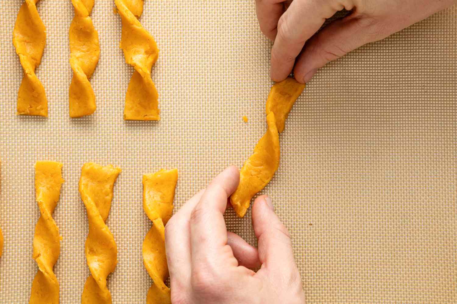 Cheese Straw Strips Twisted on a Lined Baking Sheet 