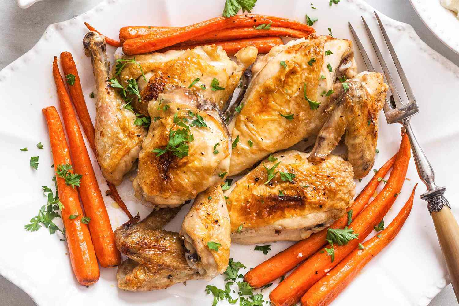 Meilleure recette de poulet rôti poulet sur une assiette blanche avec carottes et herbes