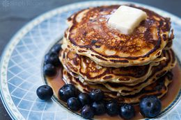 Pancakes aux myrtilles empilés avec du beurre et des myrtilles fraîches