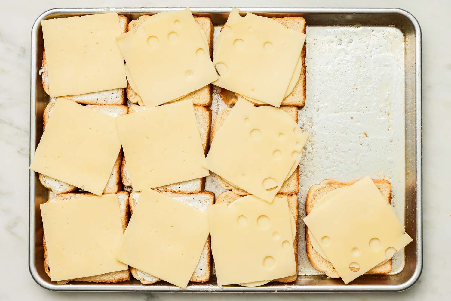 Cheese Slices Added to Each Slice of Bread on the Sheet Pan