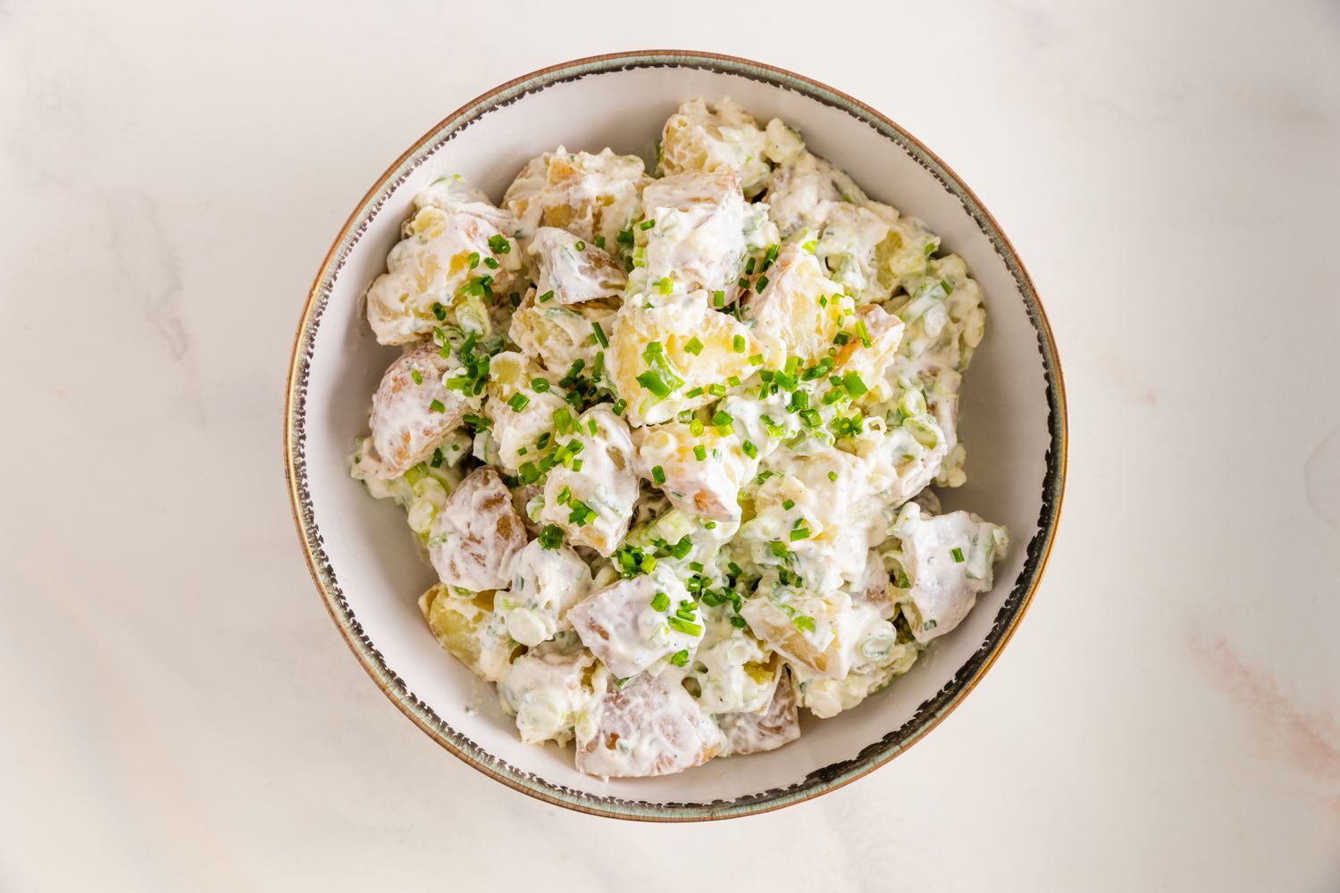 Bol de salade de pommes de terre à la crème aigre et à l'oignon