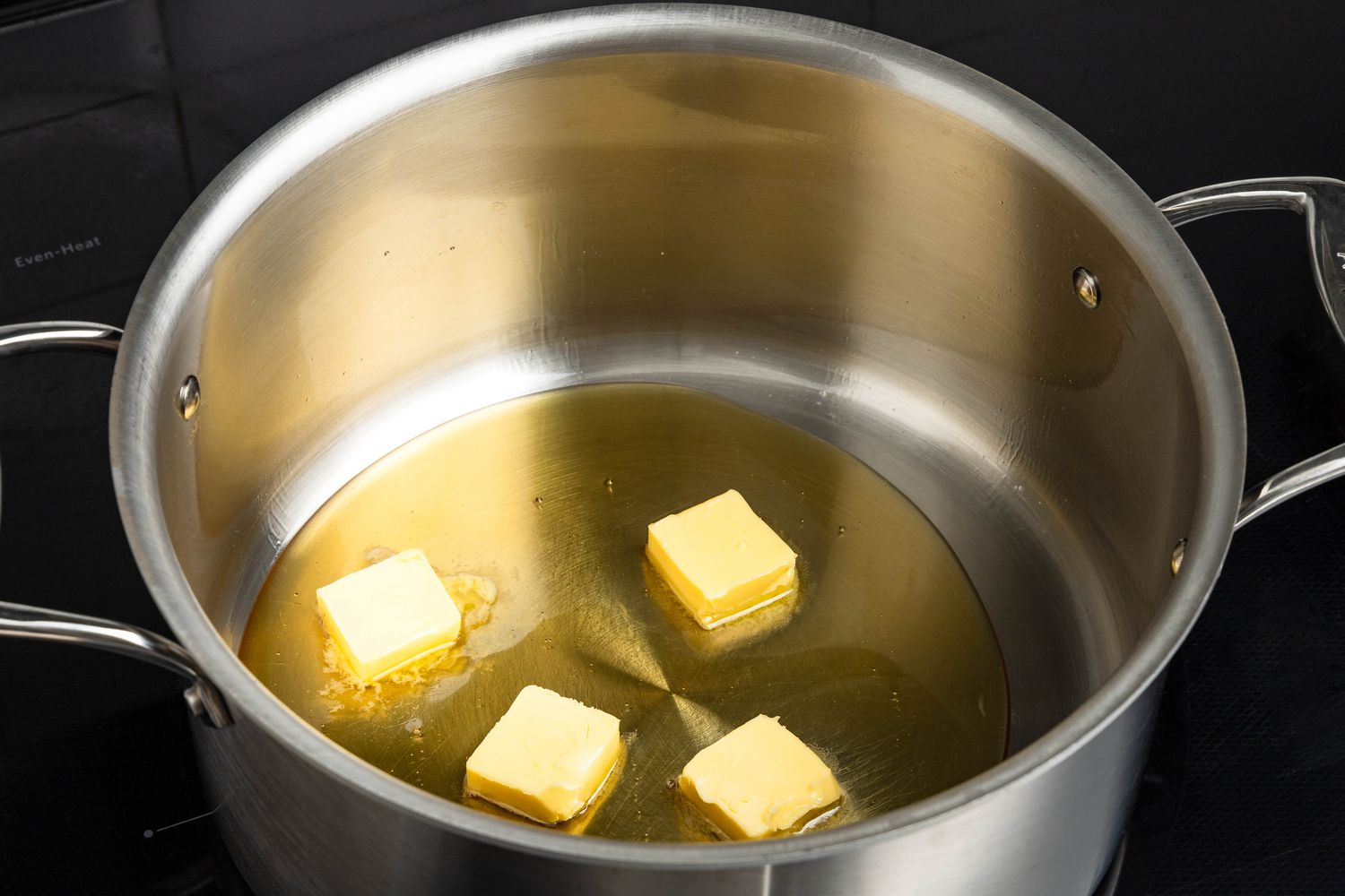 Cubes of butter and honey in the large pot for honey popcorn recipe