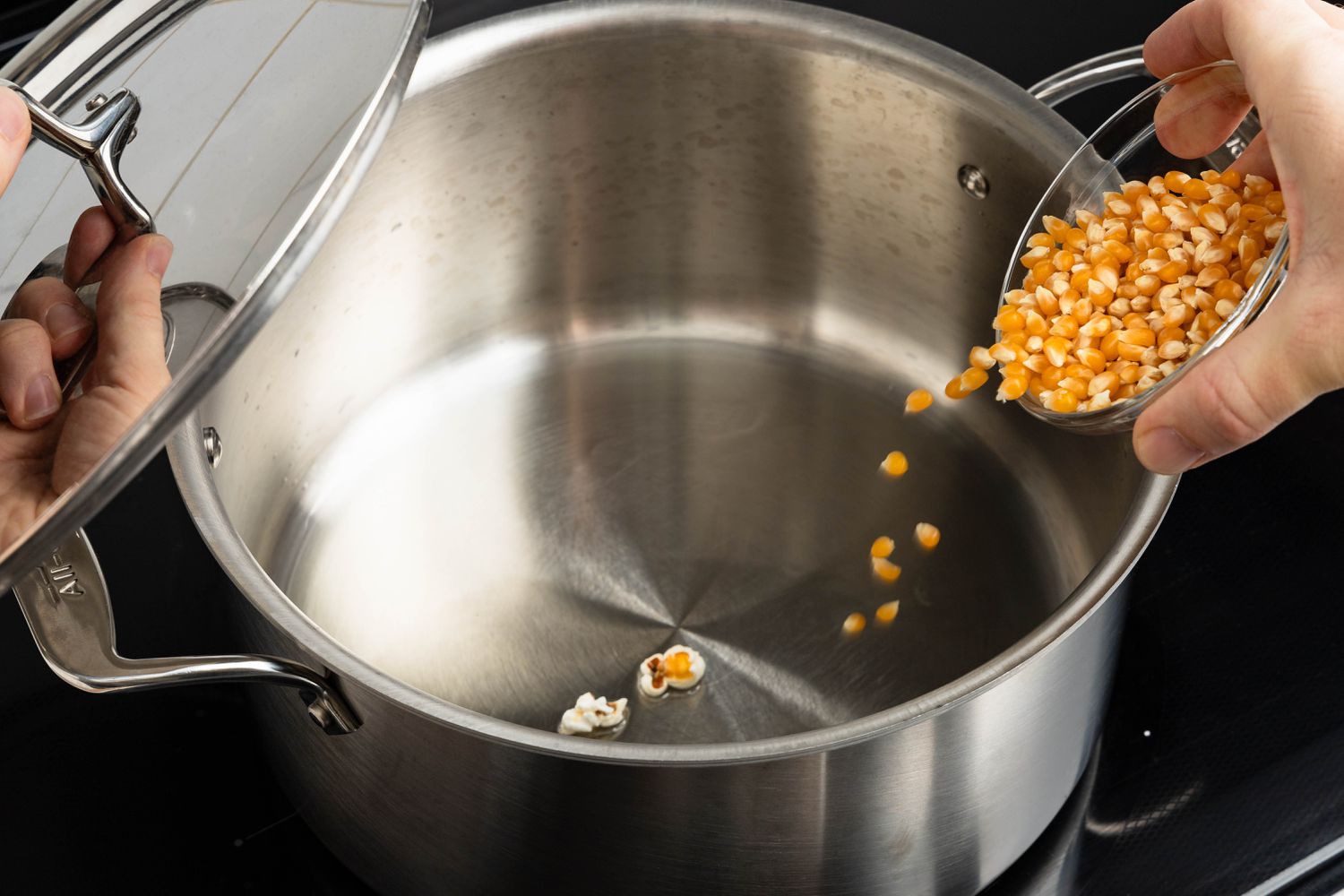 Kernels poured into a large pot with melted butter for honey popcorn recipe