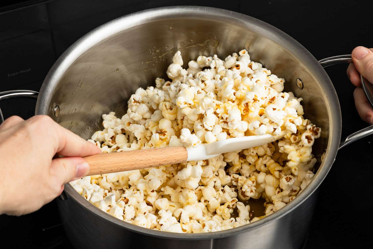 Popcorn folded into the melted honey butter mixture in the large pot, using a rubber spatula for honey popcorn recipe