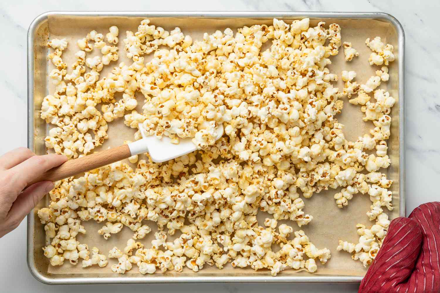 Baked honey popcorn stirred using a rubber spatula (still on the baking tray)