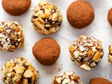 Overhead view of chocolate truffles covered in cocoa and chopped nuts.