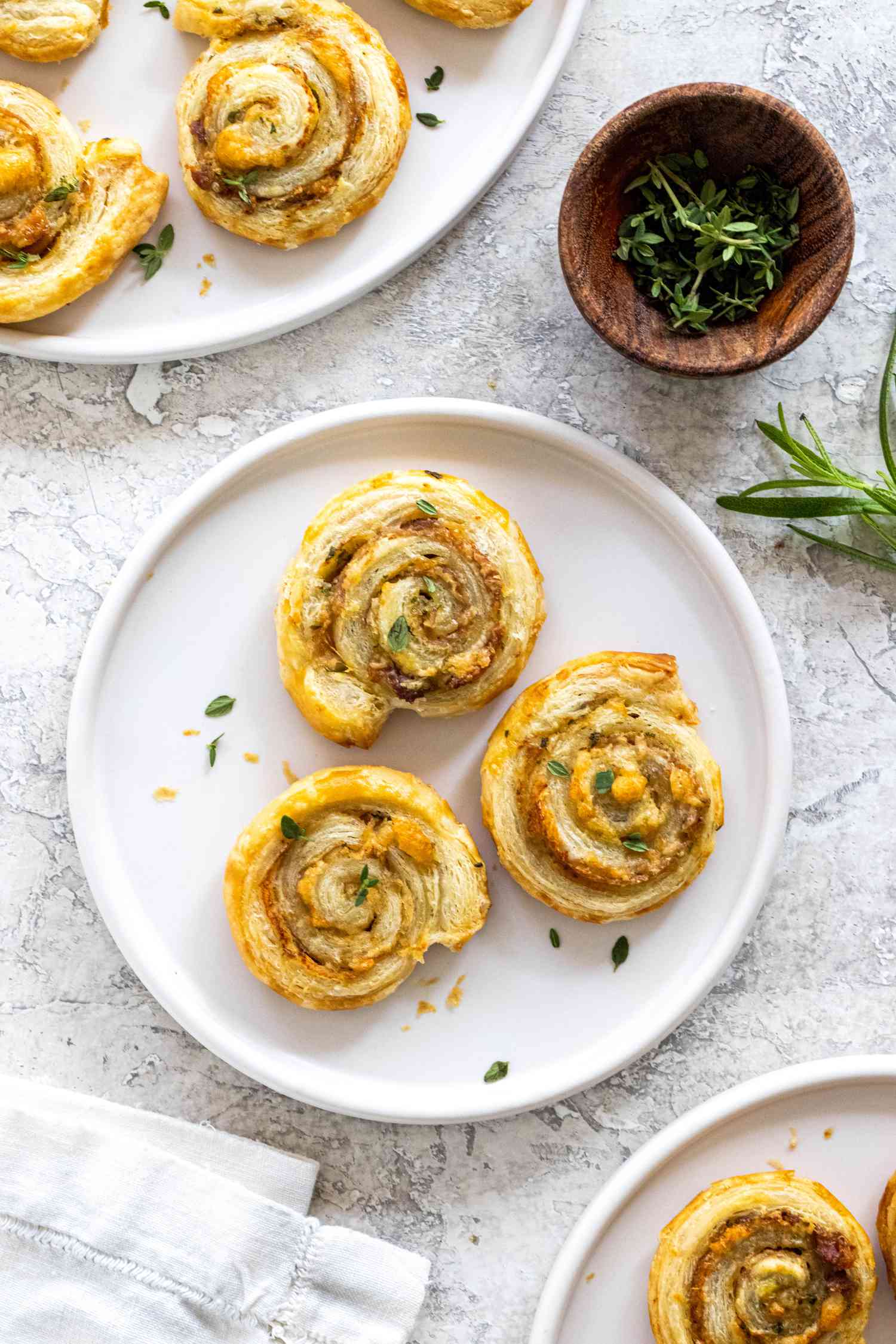 Three crispy prosciutto and parmesan pinwheels on a plate.