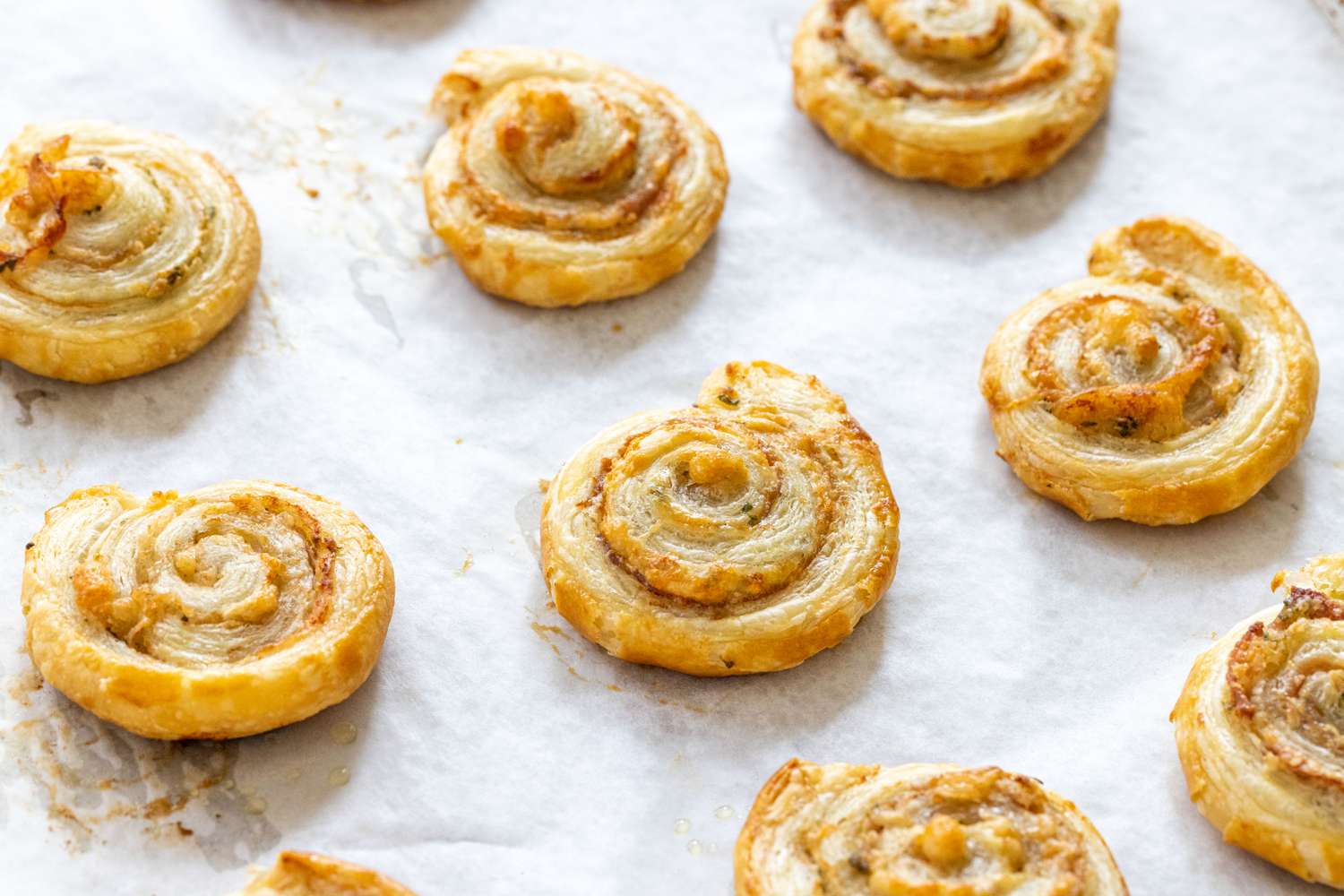 Baking sheet with crispy prosciutto and parmesan pinwheels on it.