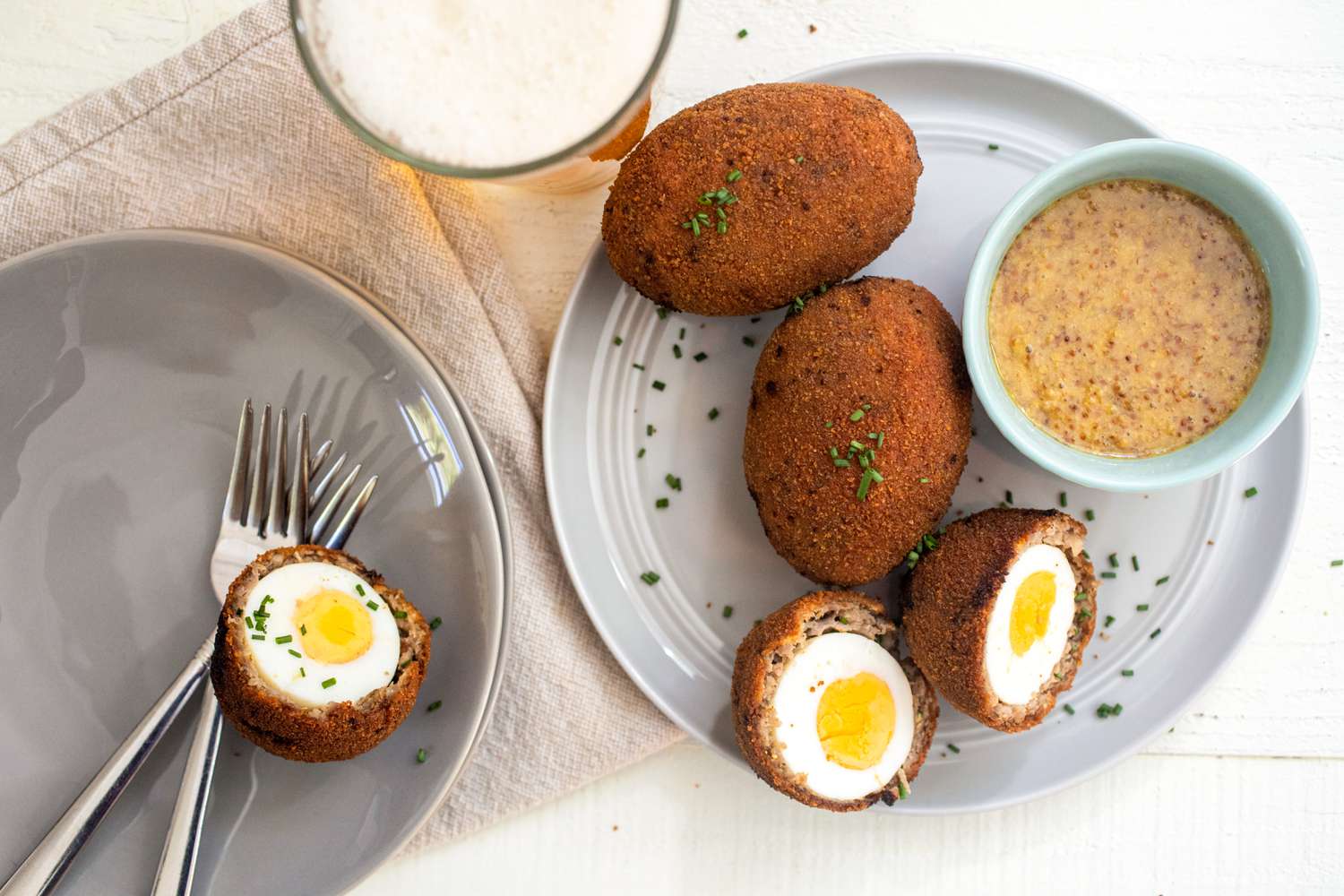 Scotch eggs servis avec une sauce miel-moutarde et de la bière.