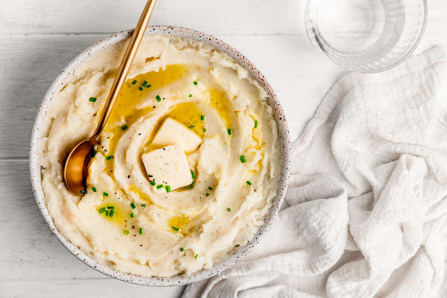 Vegan Mashed Potatoes in a Bowl Topped with Butter, Cracked Pepper, and Chives