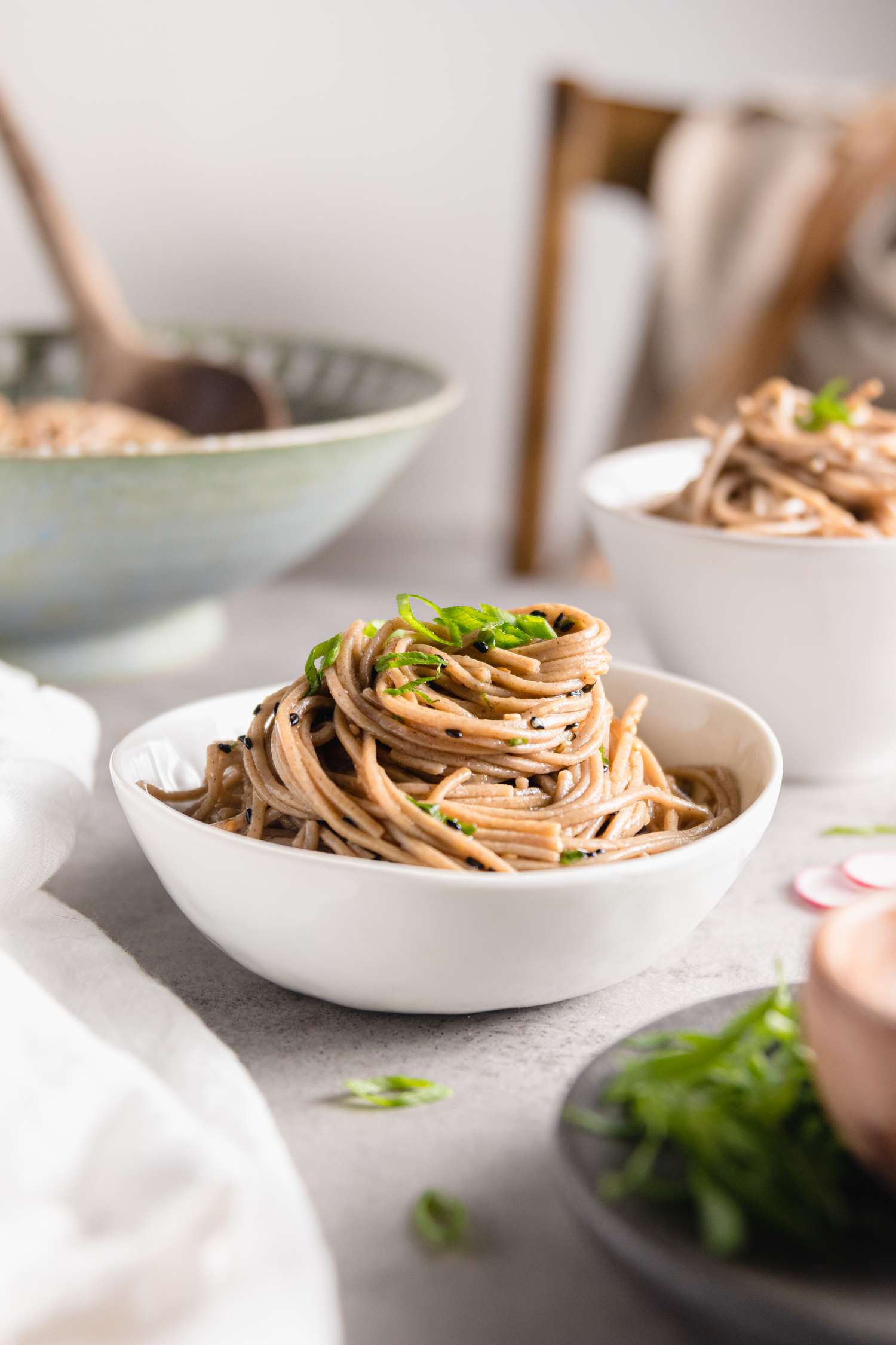 Nouilles soba au sésame dans un bol entourées de plusieurs bols de nouilles