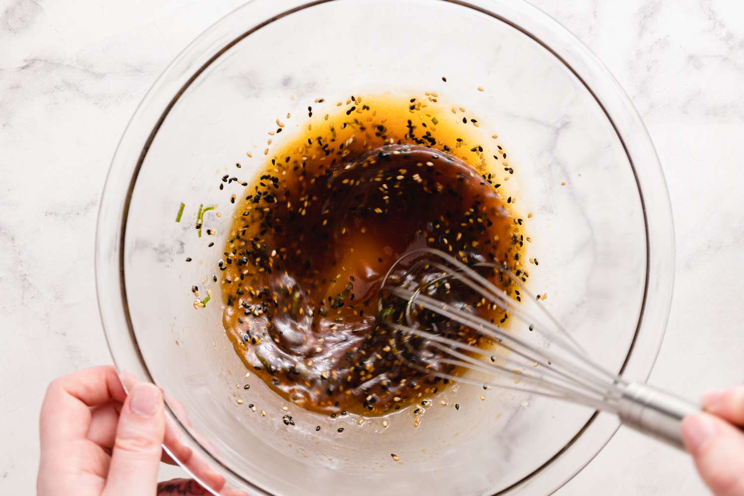 Sauce pour les nouilles soba au sésame mélangée dans un bol à l'aide d'un fouet