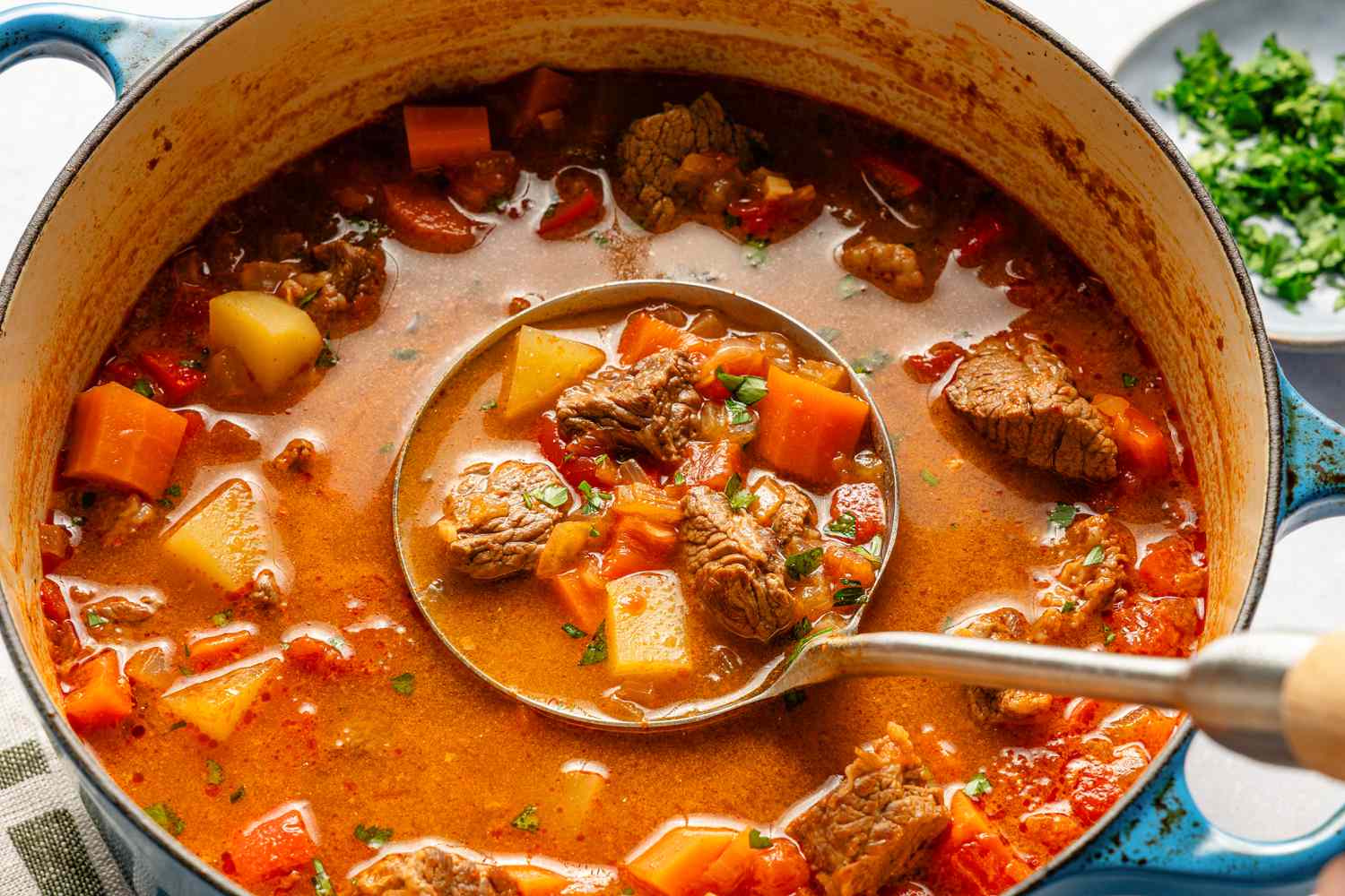 Vue aérienne d'une cocotte de goulash hongrois avec une louche au centre et une portion à l'intérieur