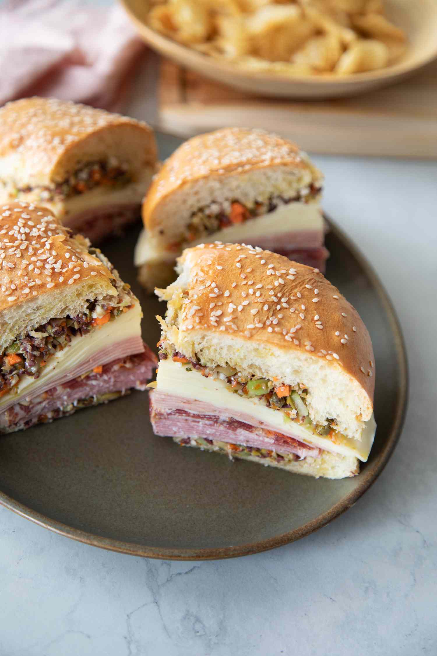 A Plate with Quarters of a Classic Muffuletta Sandwich Made with Cold Cuts, Cheese, and Olives