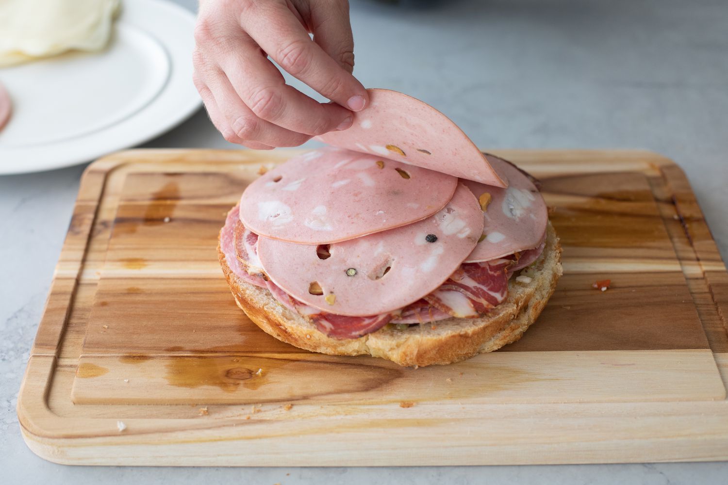 Mortadella Added to Classic Muffuletta on a Cutting Board 