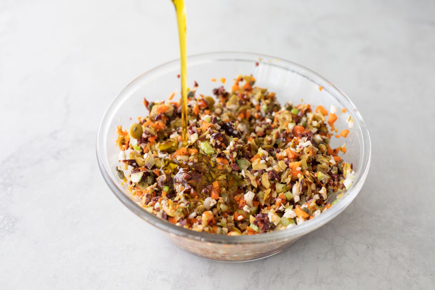 Olive Oil Added to a Bowl of Minced Olives and Cauliflower for Muffuletta Sandwich Recipe