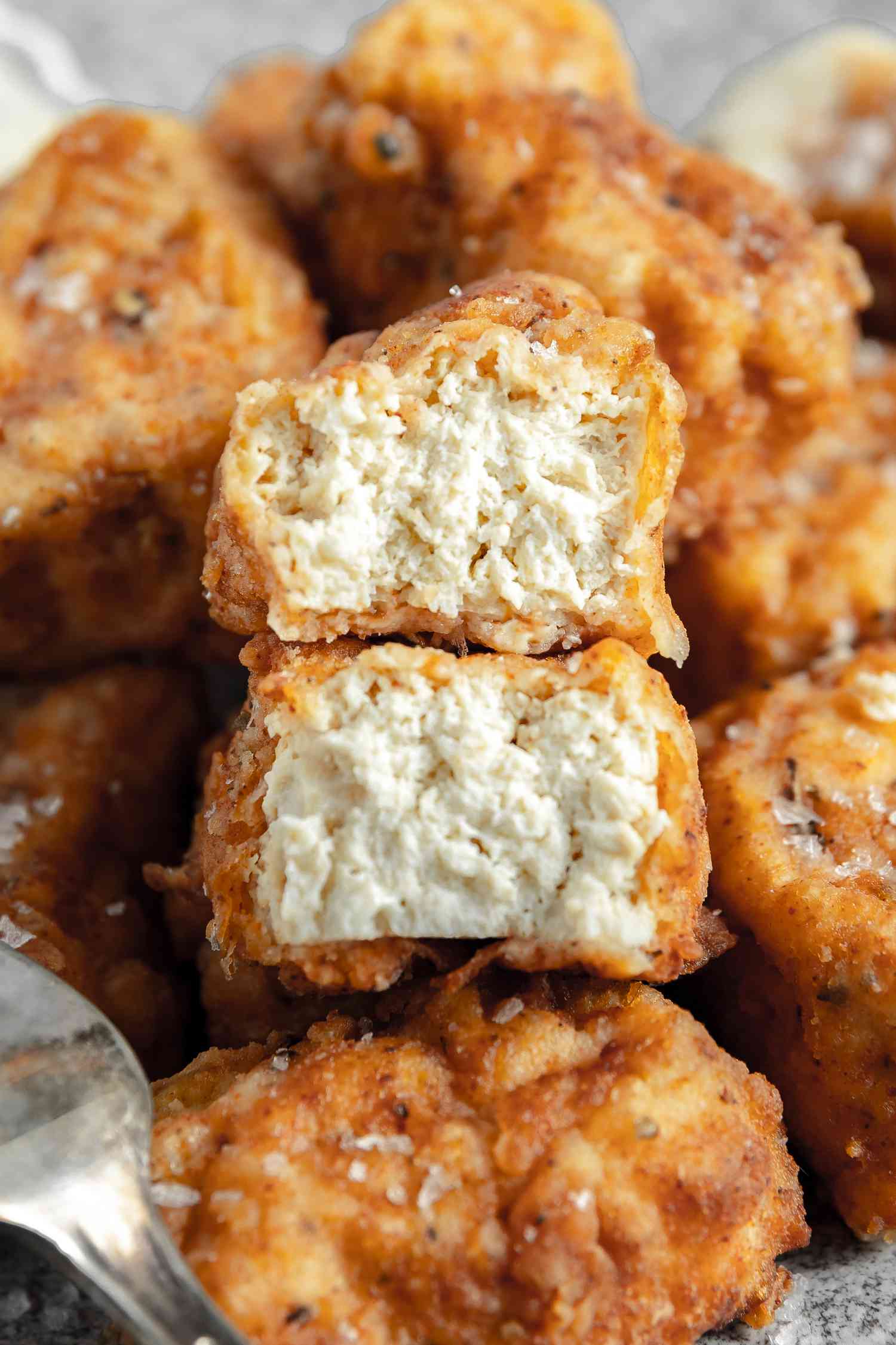 Cross Section of a Vegan Chicken Nugget Sitting on More Vegan Chicken Nuggets