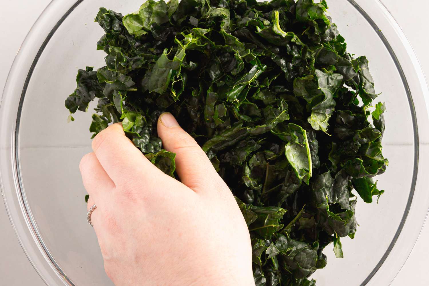 Hand Massaging a Bowl of Chopped Kale until Tender 