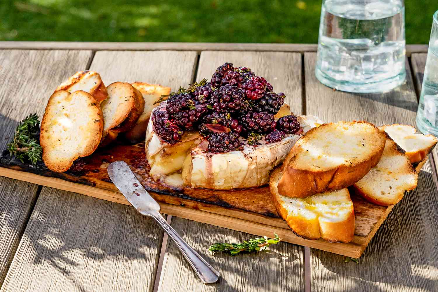 Brie Grillé sur Planche de Cèdre, Garni de Mûres et Servi sur la Planche avec des Crostinis