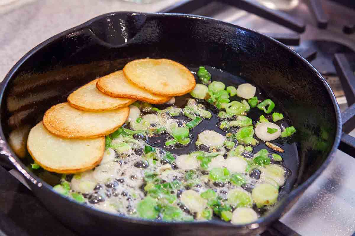 faire frémir les oignons dans une poêle en fonte pour la tortilla espagnole