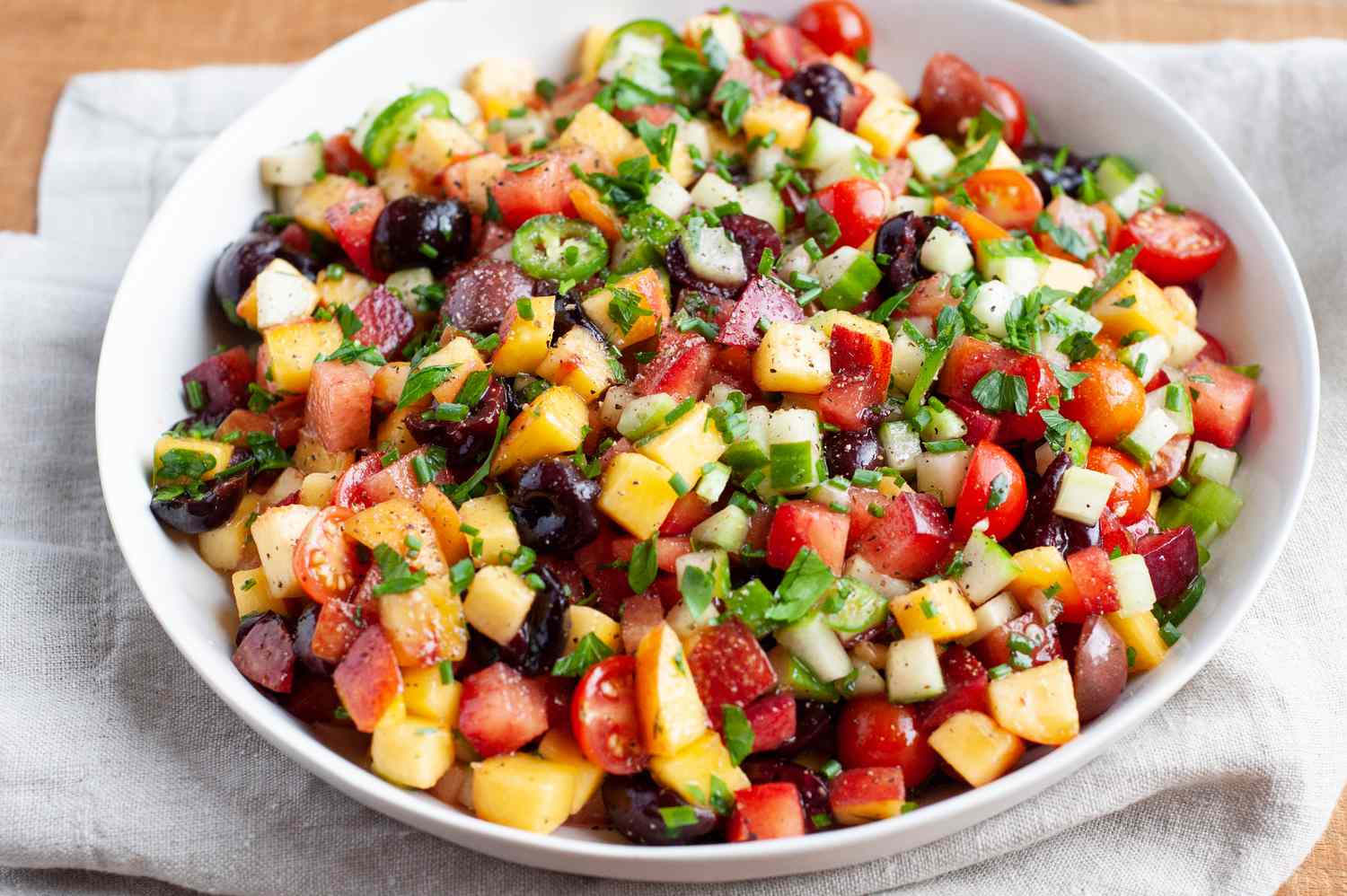 Salade de Fruits à Noyau et Légumes dans un Bol de Service avec un Lin sous.