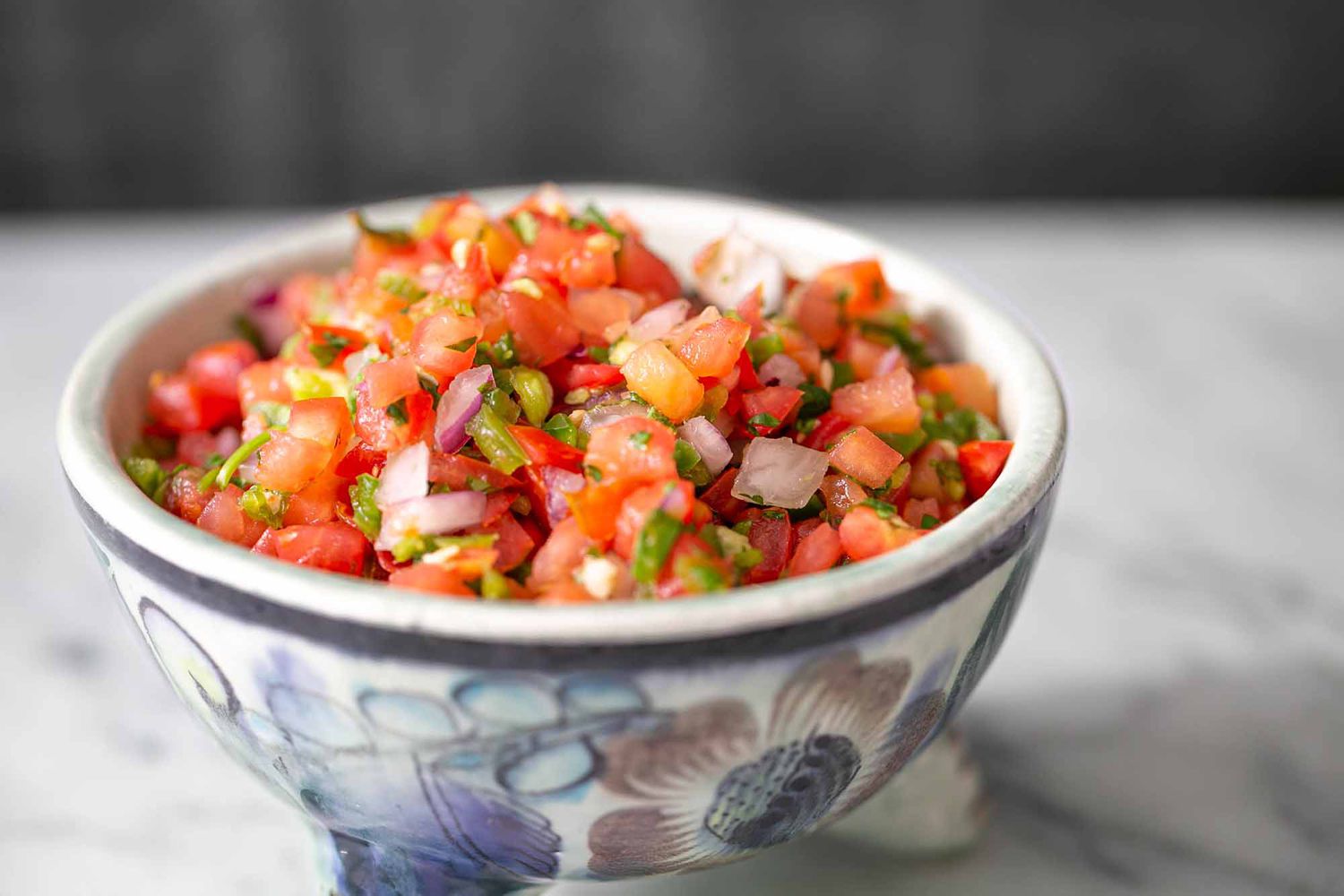 salsa de tomate dans un bol montrant des tomates hachées et de l'oignon