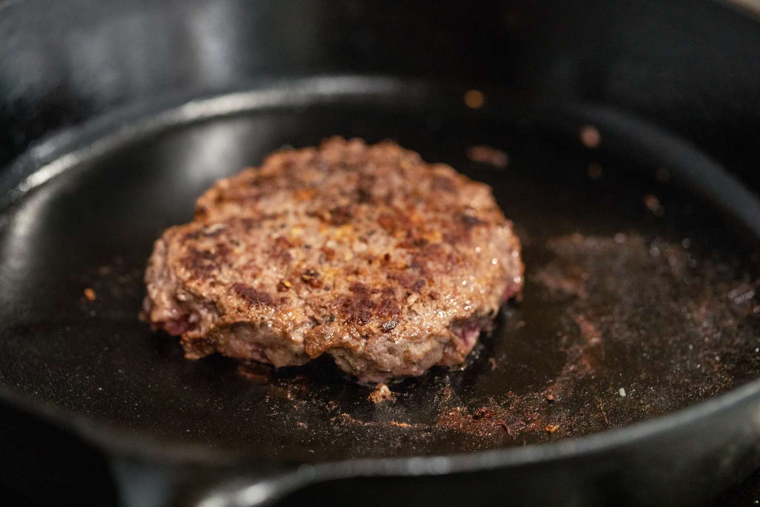 Galette de hamburger cuite dans la poêle en fonte pour comment cuisiner un hamburger sur la cuisinière