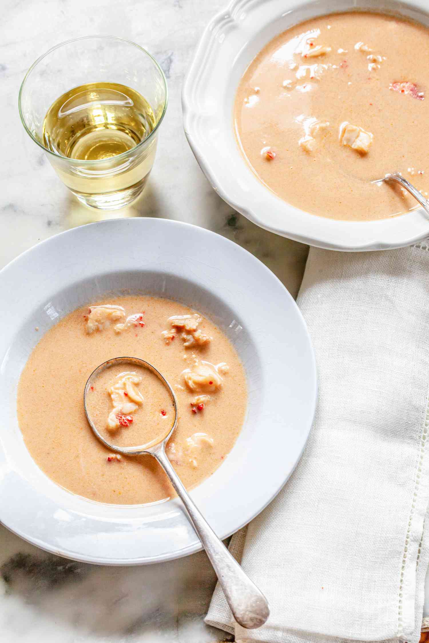 Deux Bols de Bisque de Homard à Côté d'une Serviette de Table et d'un Verre