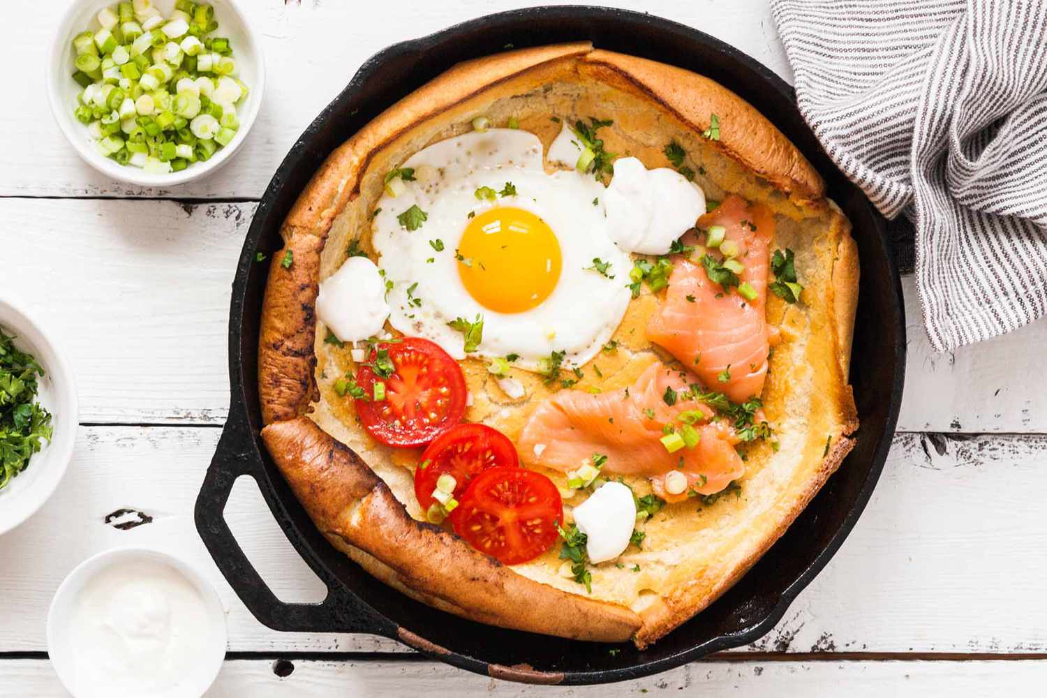 Crêpe hollandaise garnie d'œuf, saumon et tomates dans une poêle