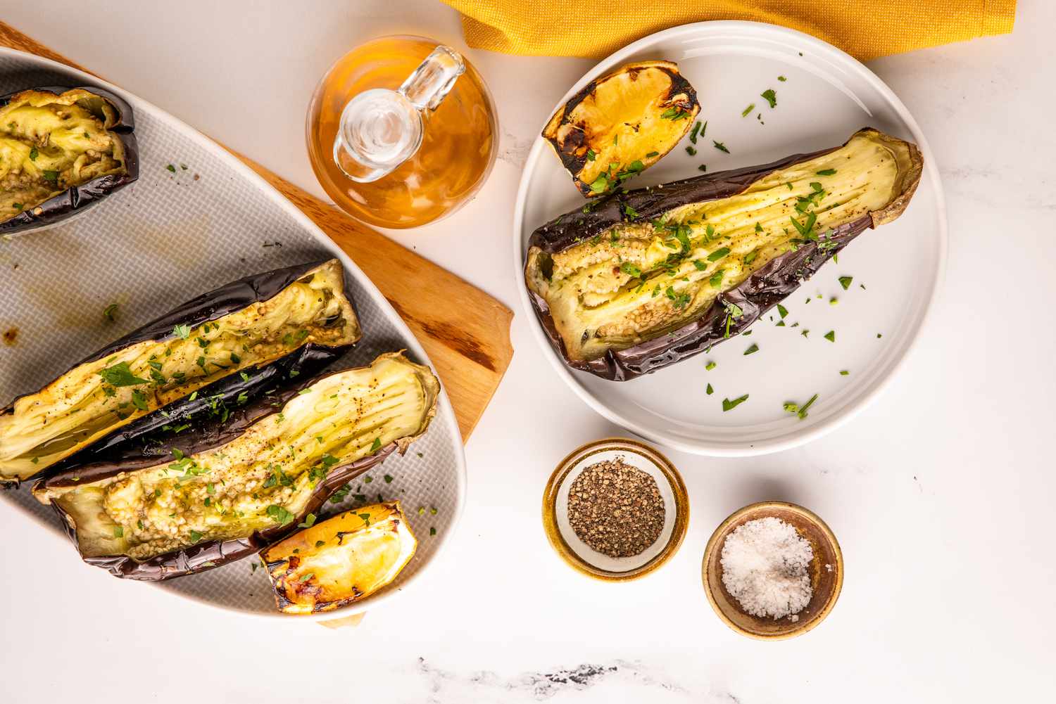 Plat d'Aubergine Grillée Entière Entourée de Bols de Sel et de Poivre