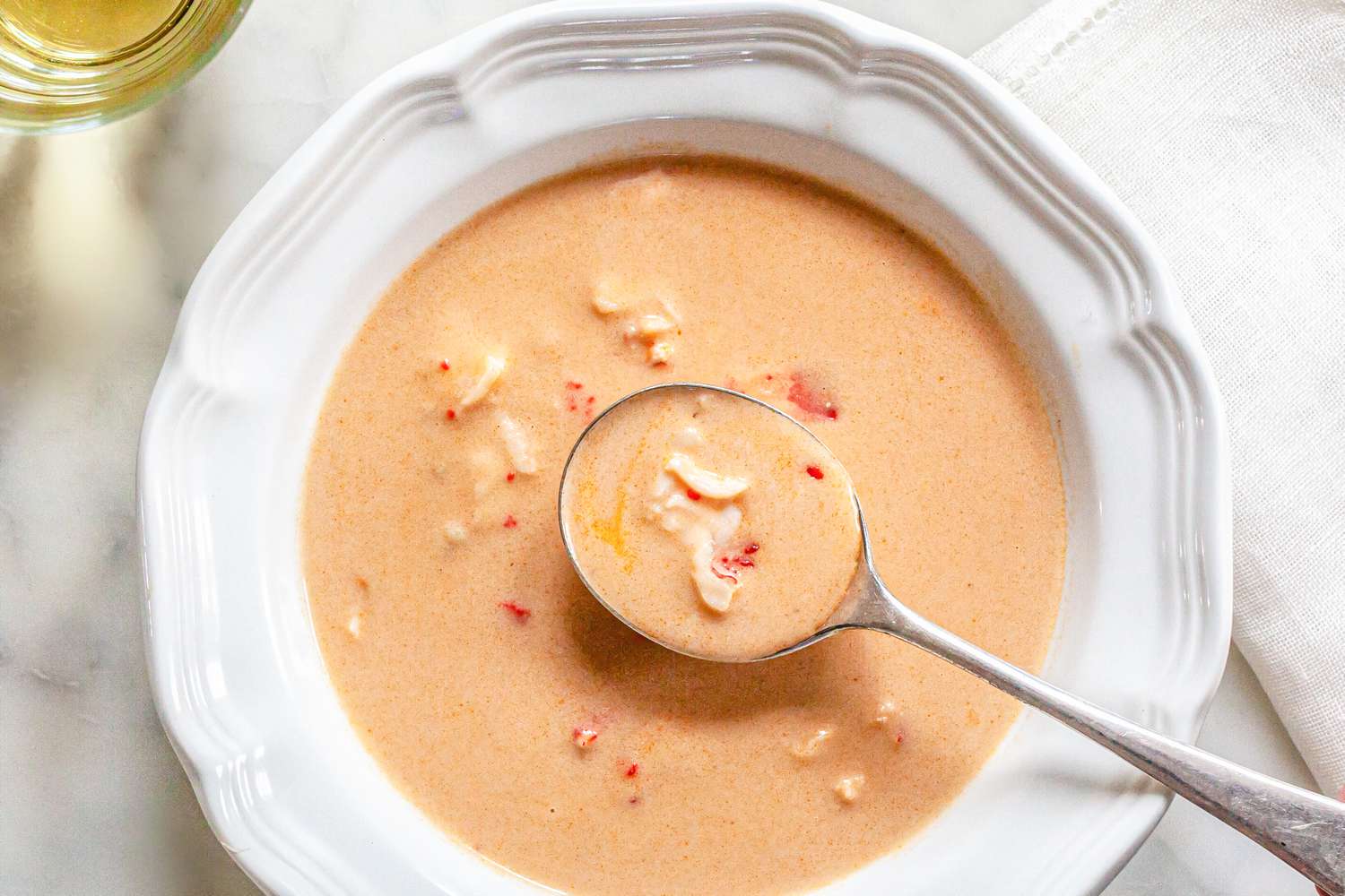 Bol de Bisque de Homard avec une Cuillère à Côté d'un Verre